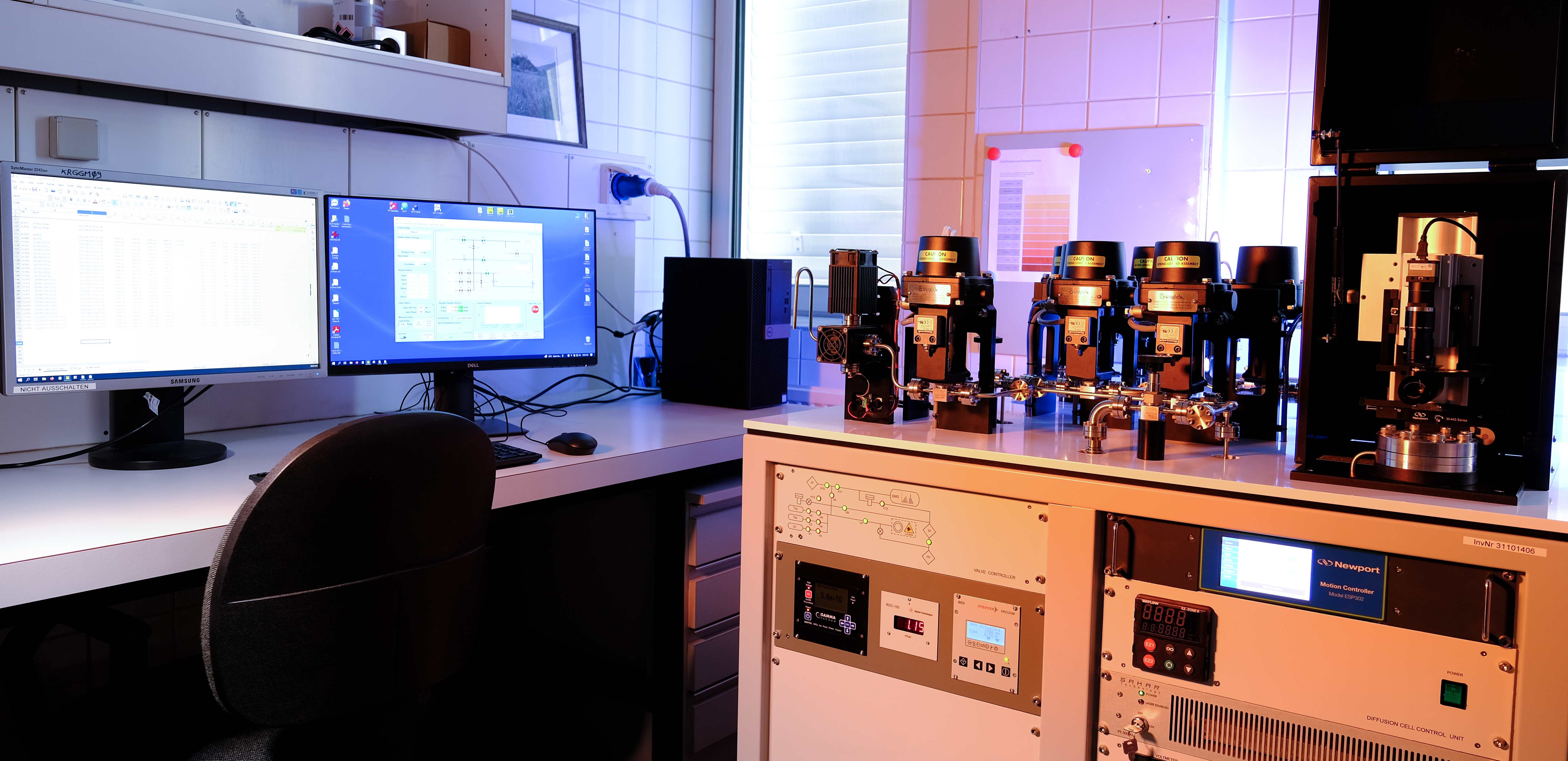 Alphachron system under warm blue and amber laboratory lighting showing the full workstation and control hardware
